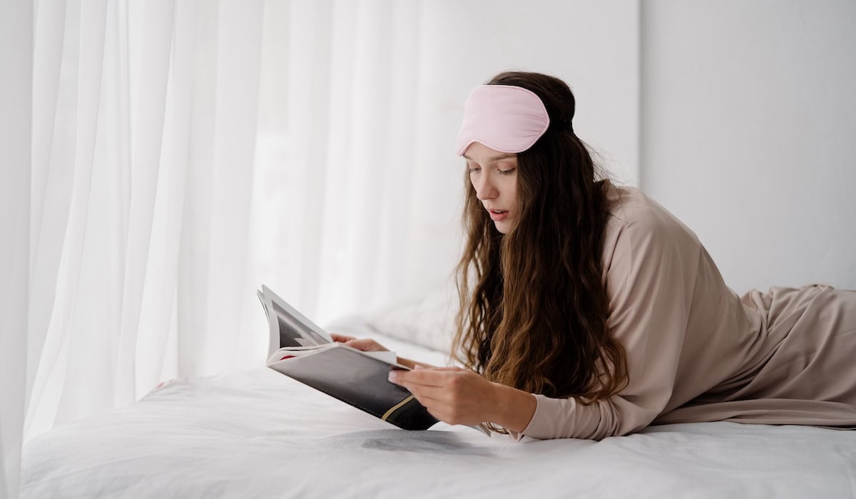 woman sits on bed reading about my Evening Routine Ideas to Help You Wind Down at Night