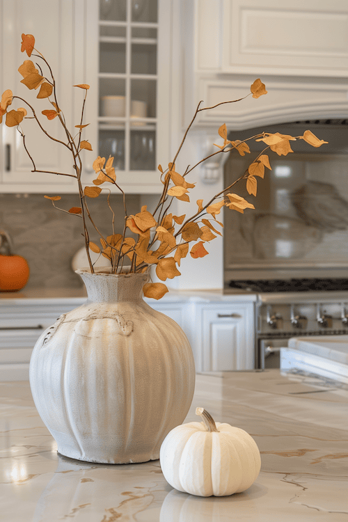 Cute little white pumpkin and Fall foliage on kitchen counter