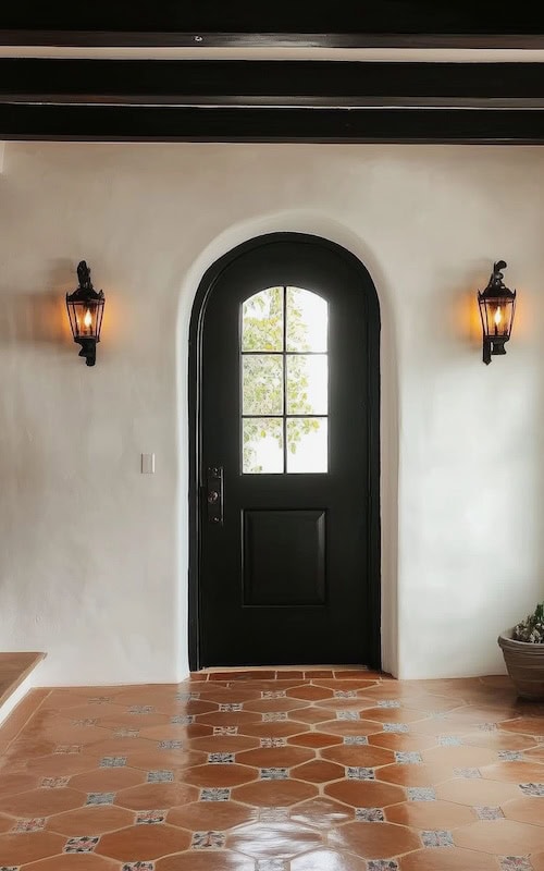 spanish revival entryway with wrought iron wall sconces